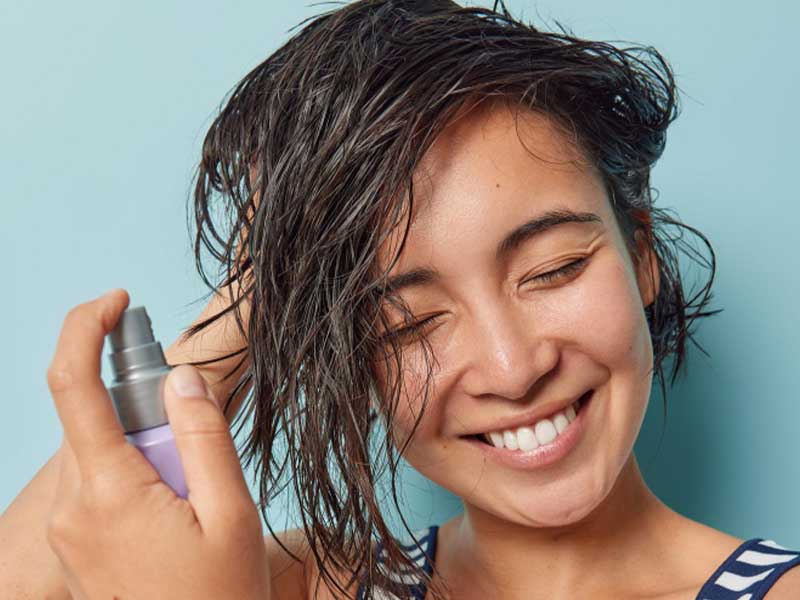 Spraying haircare product on hair