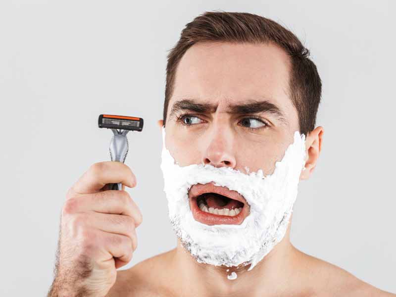 Man with acne shaving